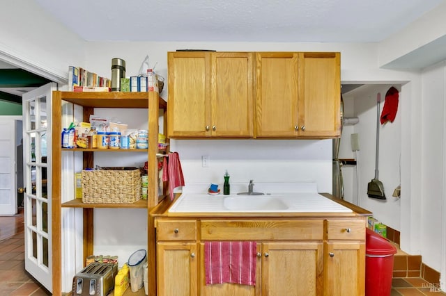 kitchen featuring sink and dark tile patterned flooring