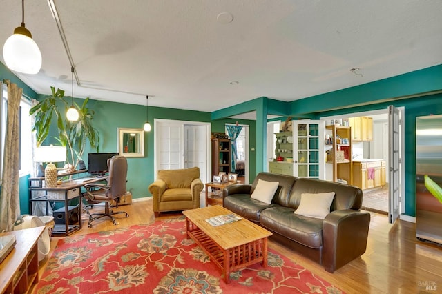 living room with hardwood / wood-style flooring, a wealth of natural light, and french doors