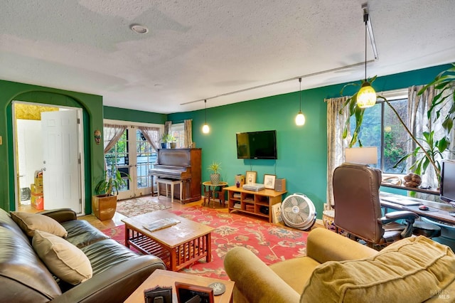 living room with a textured ceiling and french doors