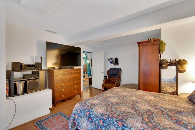 bedroom featuring light hardwood / wood-style flooring and a textured ceiling