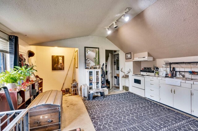 kitchen with white cabinets, a textured ceiling, dark colored carpet, and electric stove