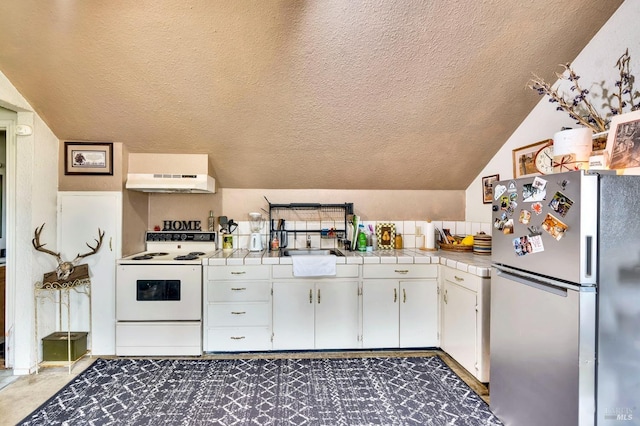 kitchen featuring stainless steel fridge, tile countertops, white electric range, white cabinetry, and range hood