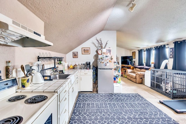 kitchen with lofted ceiling, white appliances, exhaust hood, white cabinets, and a textured ceiling