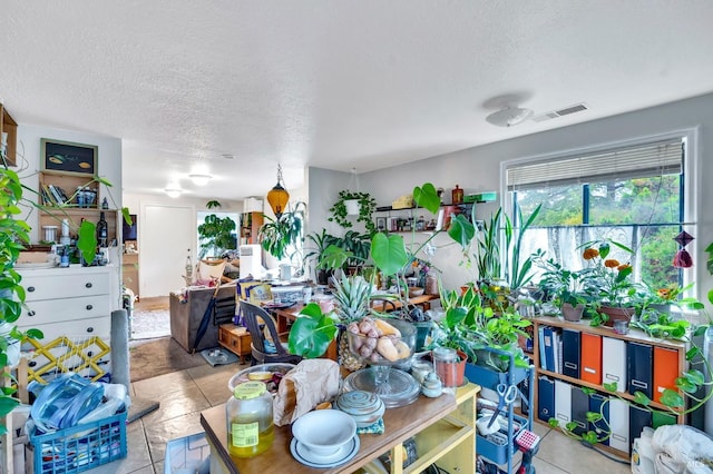 misc room featuring light tile patterned flooring and a textured ceiling