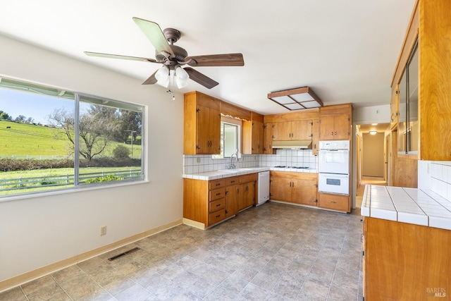 840 W Railroad Ave, Cotati, CA 94931 - kitchen with brown cabinetry, white appliances, tile countertops, and under cabinet range hood