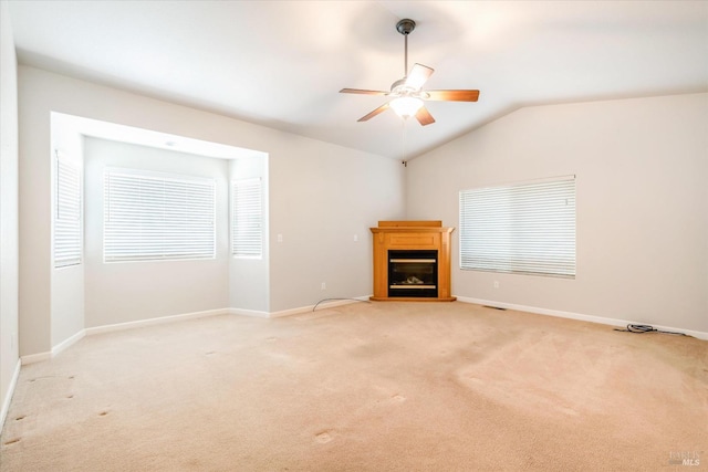 unfurnished living room featuring ceiling fan, vaulted ceiling, and light colored carpet