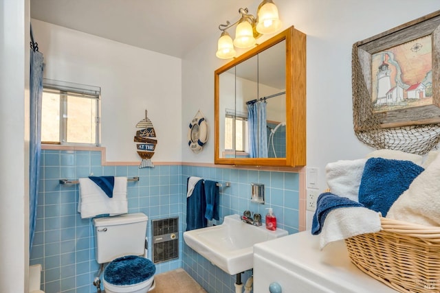 bathroom featuring sink, curtained shower, toilet, and tile walls