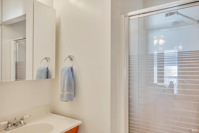 bathroom featuring walk in shower and vanity