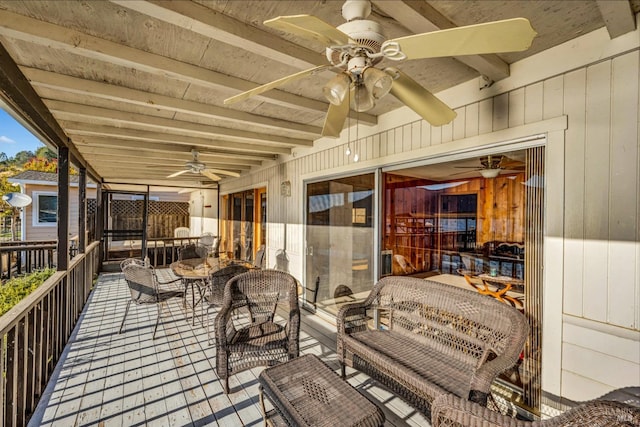 wooden terrace featuring ceiling fan and an outdoor living space