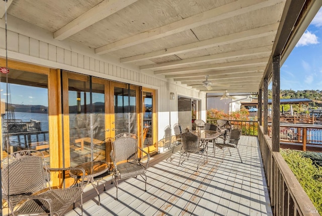 wooden deck featuring a water view and ceiling fan