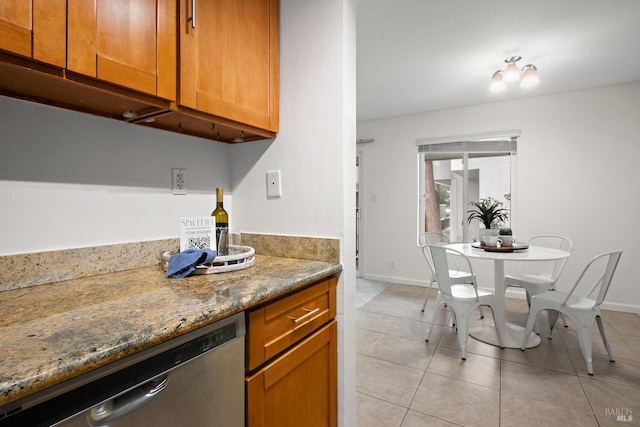 kitchen featuring dishwasher, stone countertops, and light tile patterned floors