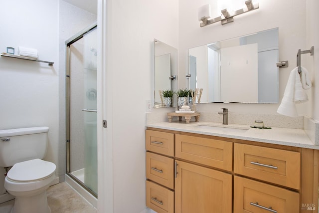 bathroom featuring vanity, a shower with shower door, and toilet