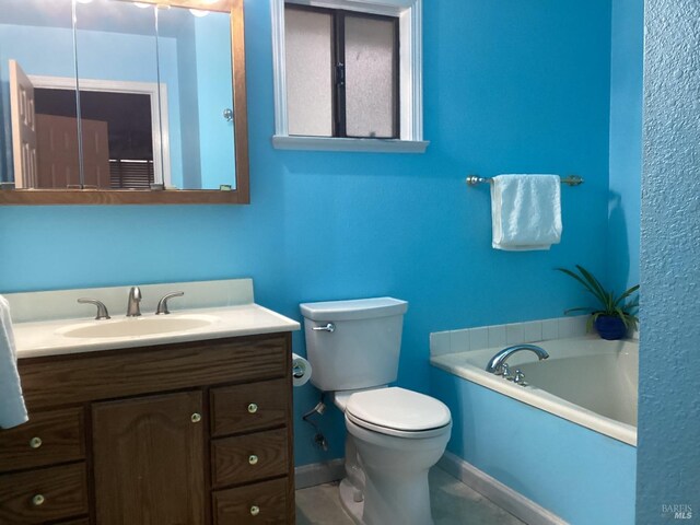 bathroom featuring vanity, toilet, tile patterned flooring, and a bathing tub