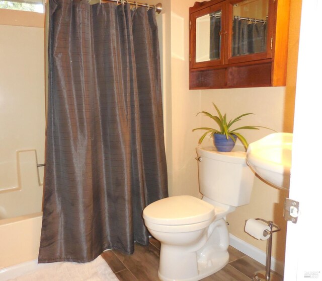 full bathroom with sink, shower / bath combo with shower curtain, and toilet