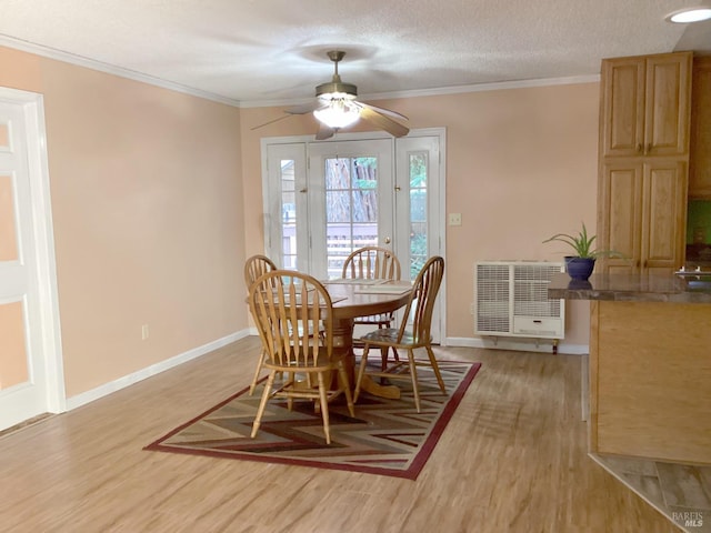 dining area with a textured ceiling, light wood-type flooring, heating unit, ornamental molding, and ceiling fan