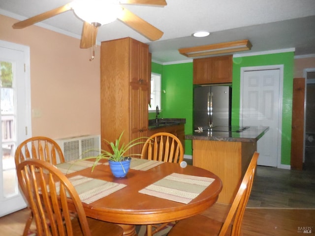 dining space with sink, ceiling fan, a wealth of natural light, and dark wood-type flooring