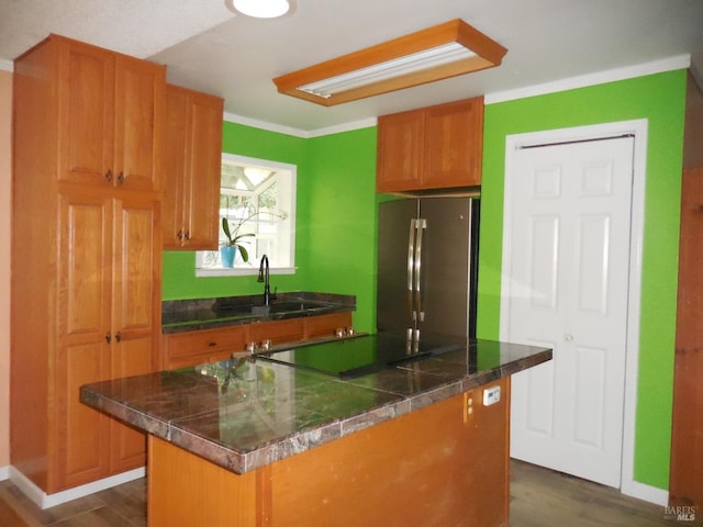 kitchen featuring sink, a kitchen island, dark hardwood / wood-style floors, and stainless steel refrigerator