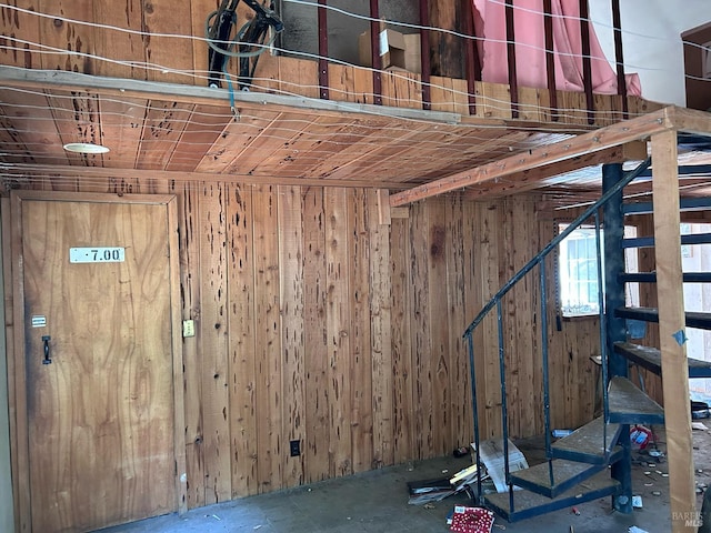 basement featuring wooden walls