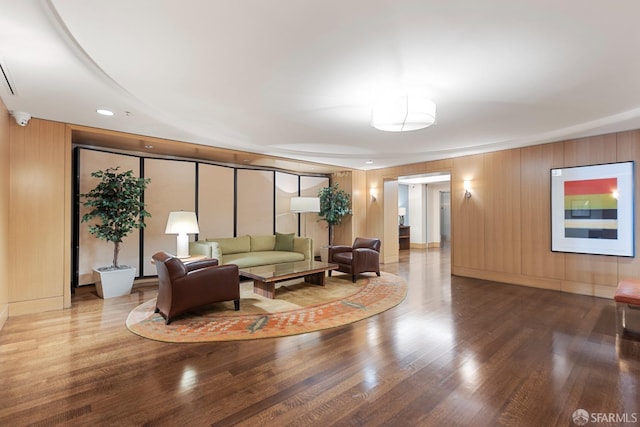 living room with wood walls and wood-type flooring