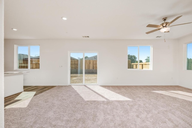 carpeted empty room with visible vents, recessed lighting, a ceiling fan, and baseboards