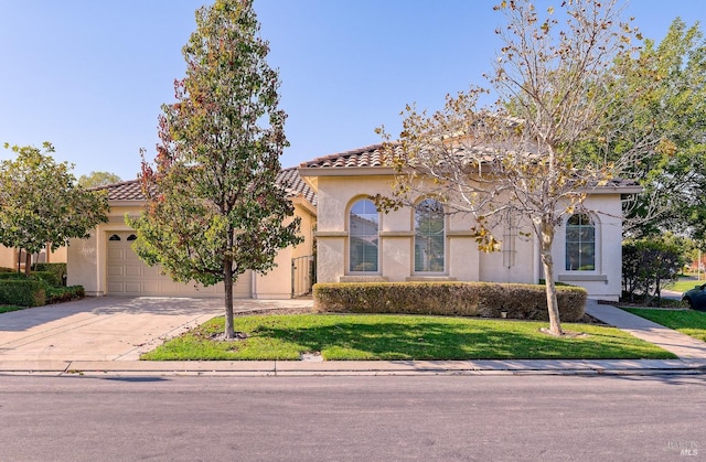 mediterranean / spanish-style house with a garage and a front lawn