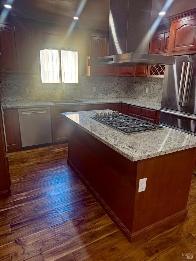 kitchen featuring dark hardwood / wood-style flooring, a kitchen island, appliances with stainless steel finishes, and sink