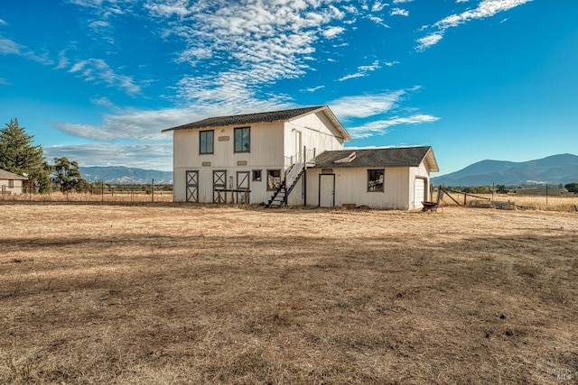 back of house featuring a mountain view and a rural view