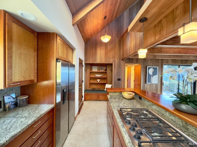 33755 Yardarm Dr Unit 15-1, The Sea Ranch, CA 95497 - kitchen featuring stainless steel appliances, brown cabinets, light tile patterned floors, wood walls, and beam ceiling