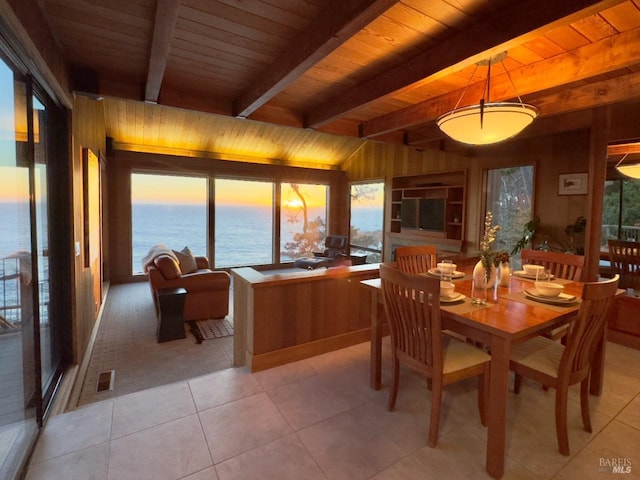 dining area featuring wood walls, beamed ceiling, wooden ceiling, and light tile patterned floors