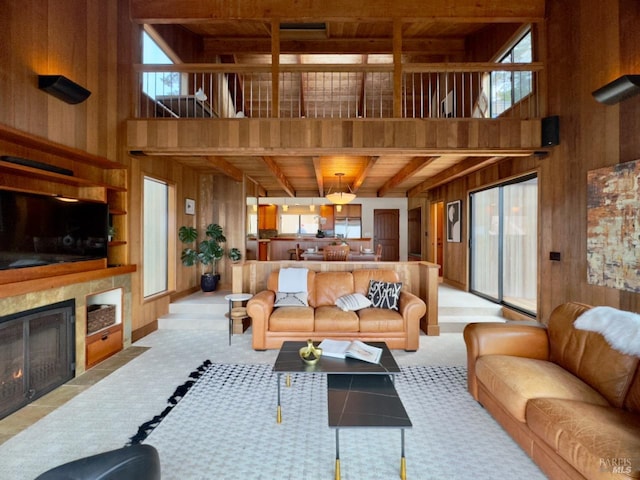 living room featuring a towering ceiling, beam ceiling, wooden walls, and wooden ceiling