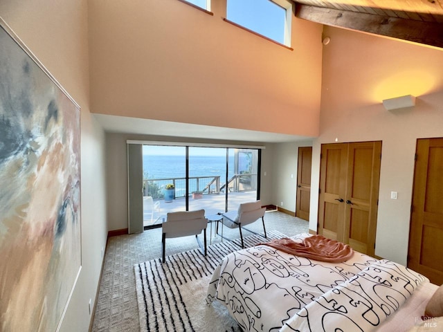 bedroom with a water view, beam ceiling, carpet flooring, high vaulted ceiling, and access to outside