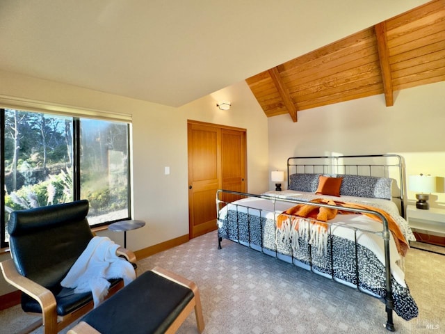 bedroom with light colored carpet, vaulted ceiling with beams, and wooden ceiling