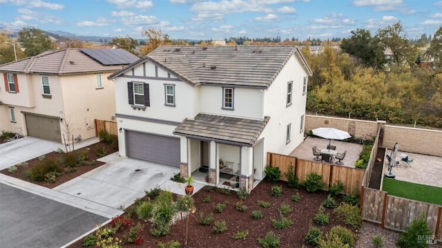 view of front of property with a garage and solar panels