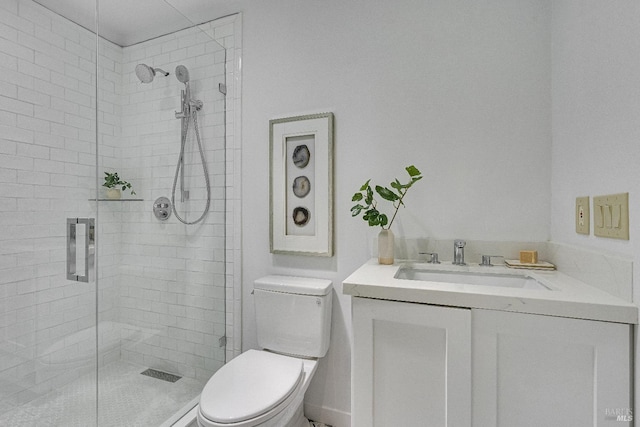 bathroom featuring vanity, toilet, and a shower with shower door