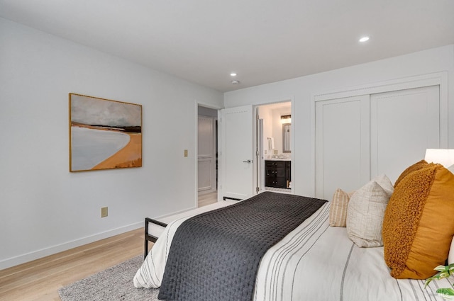 bedroom with light hardwood / wood-style flooring, connected bathroom, and a closet