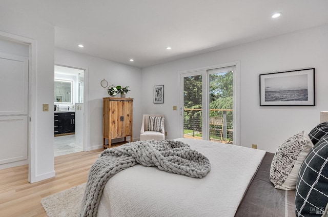 bedroom with ensuite bathroom, light hardwood / wood-style flooring, and access to outside