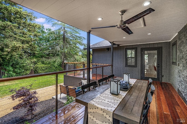 deck featuring ceiling fan and a lawn