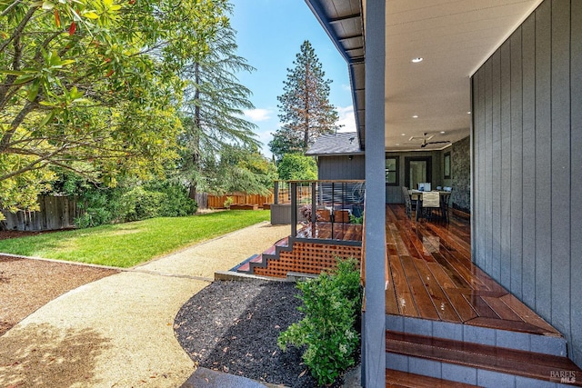 view of yard with a deck and ceiling fan