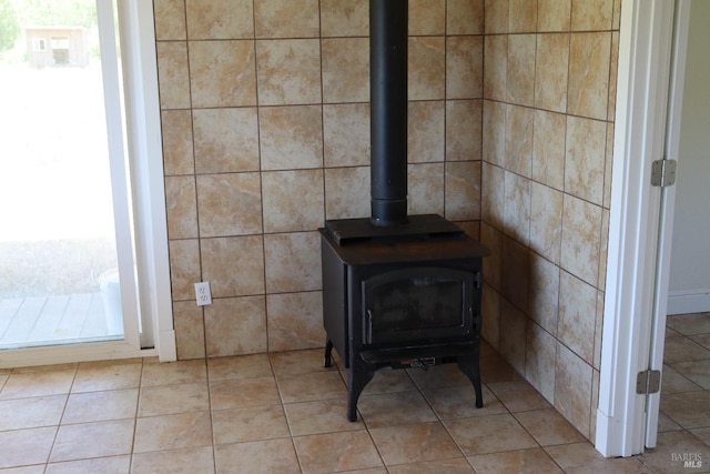 room details featuring a wood stove and tile patterned flooring