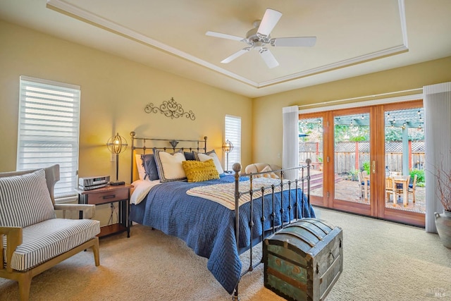 bedroom with access to exterior, ceiling fan, a raised ceiling, and carpet flooring