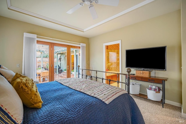 carpeted bedroom featuring a tray ceiling, access to exterior, and ceiling fan