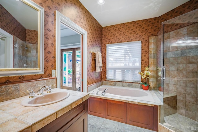 bathroom with tile patterned flooring, vanity, and shower with separate bathtub