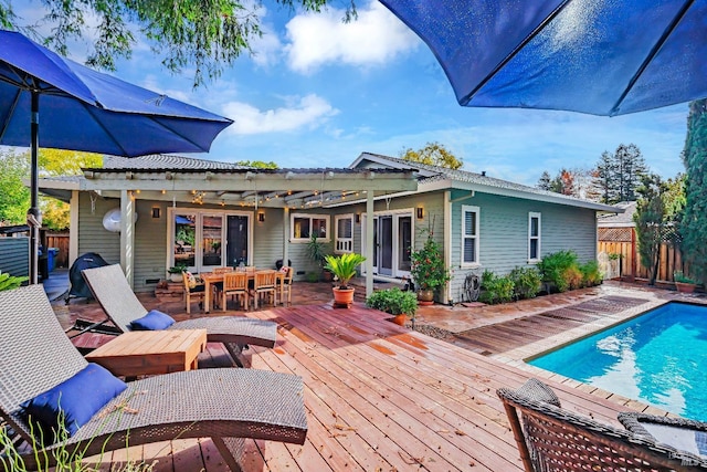 exterior space with a bar, a wooden deck, and french doors