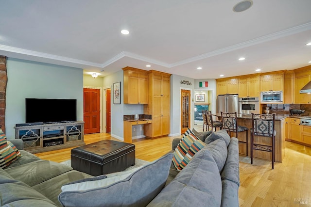 living room with light hardwood / wood-style floors and crown molding