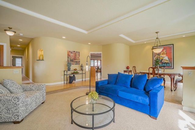 living room with a raised ceiling and ornamental molding