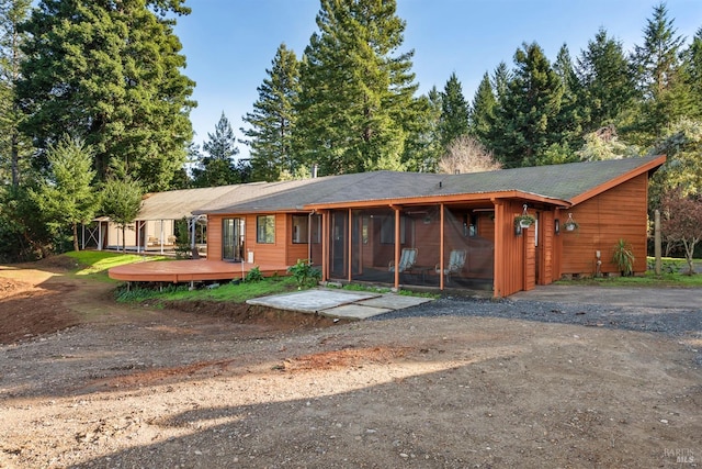 ranch-style house with a wooden deck and a sunroom