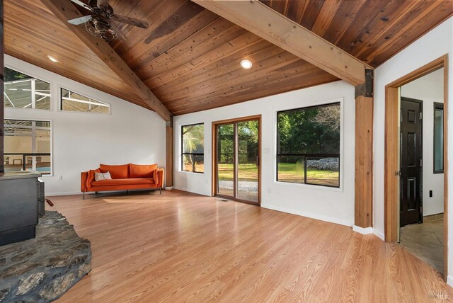 living room featuring wooden ceiling, a wood stove, ceiling fan, and light wood-type flooring