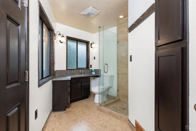 bathroom with vanity, toilet, backsplash, and a shower with door