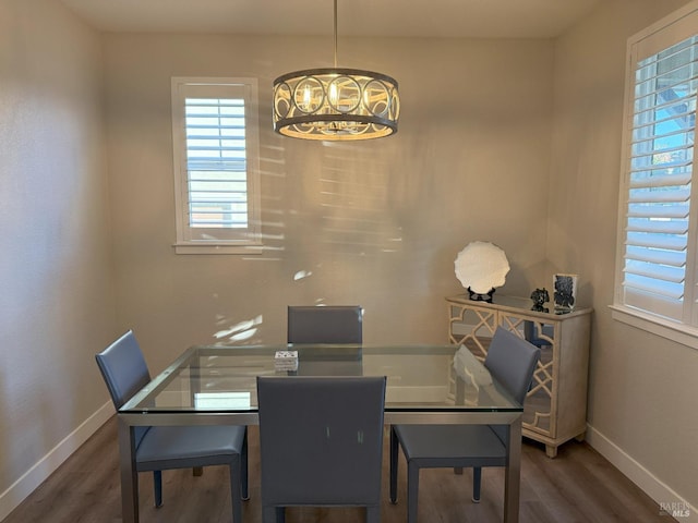 dining area featuring dark hardwood / wood-style flooring and an inviting chandelier