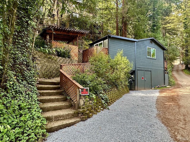 exterior space featuring gravel driveway and stairway